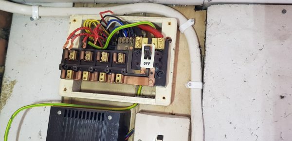 Picture 2: Image of orginal fuse board in process of being removed. You can see the exposed electrical wires. 